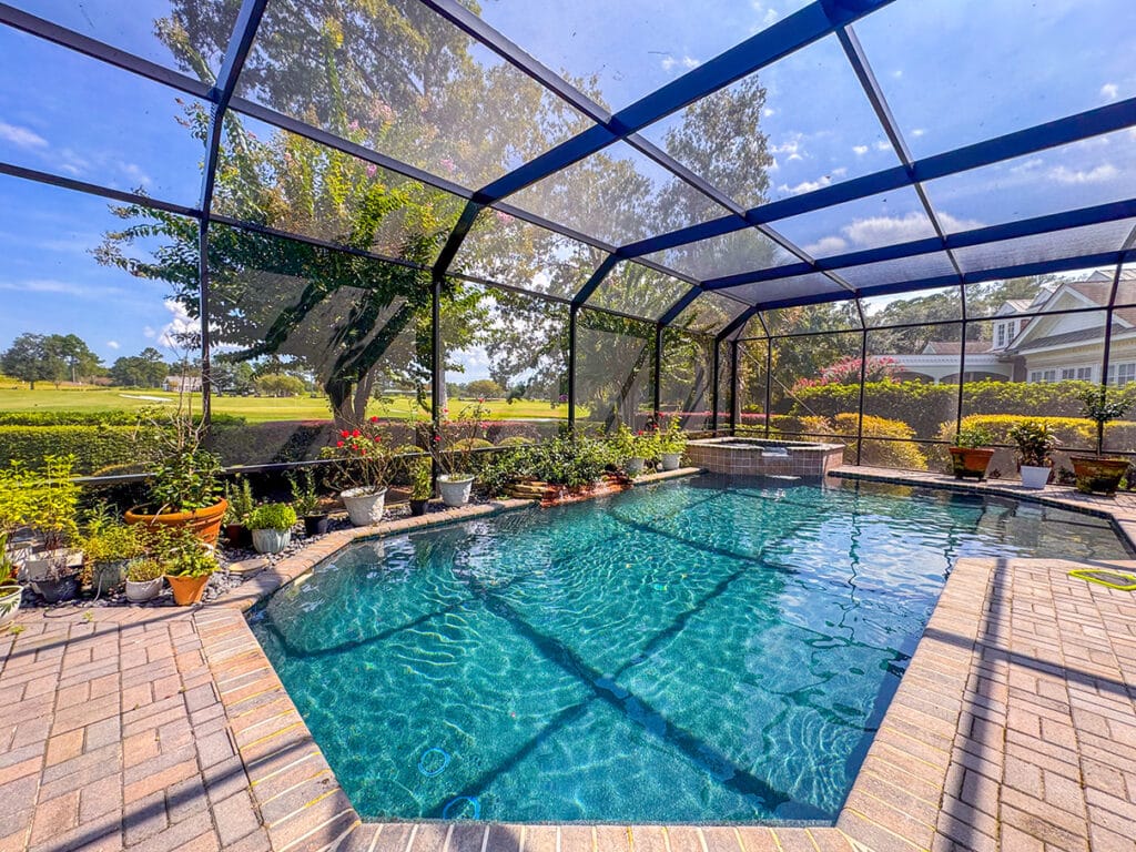 Outdoor dining area inside screened enclosure