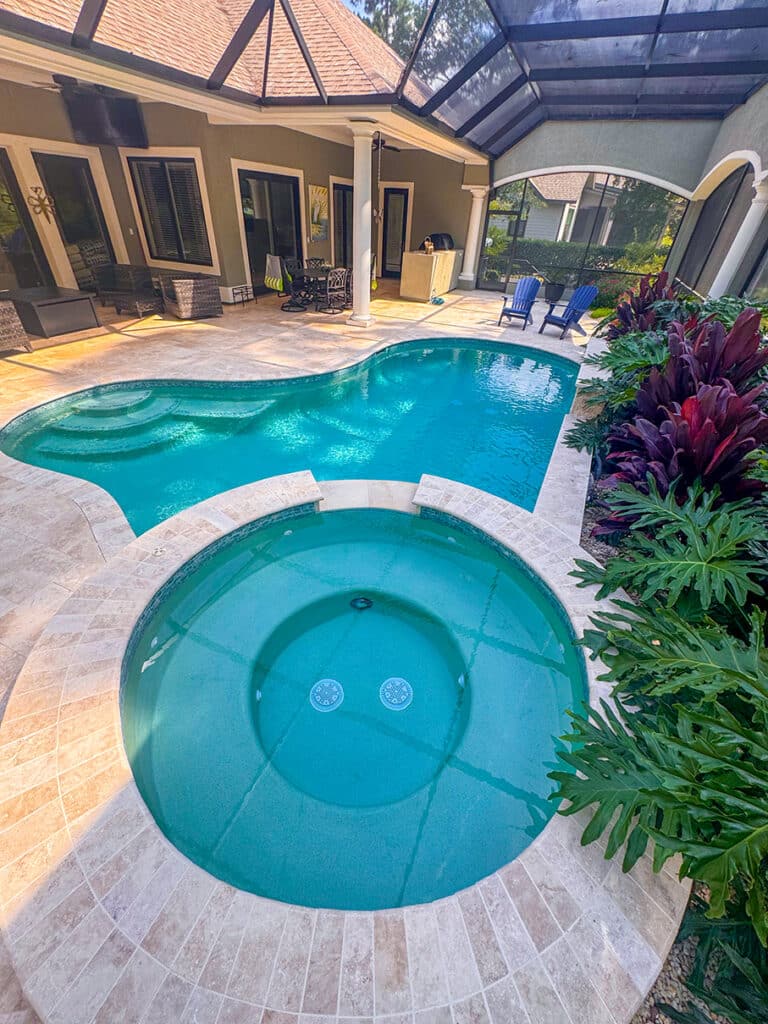 Spa and pool combo with curved design and landscaping
