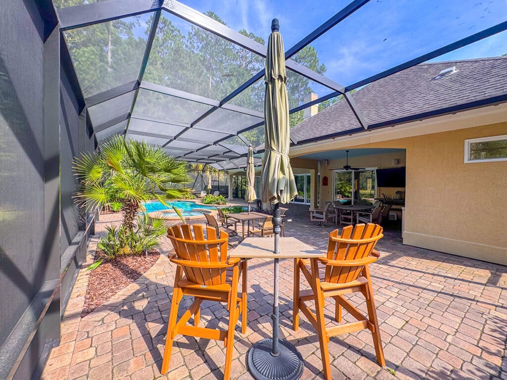 Patio seating area with wooden chairs inside enclosure